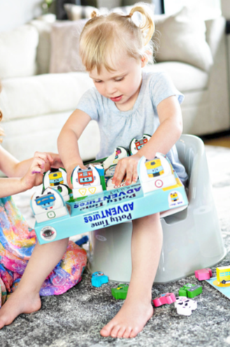 Child playing with a potty training toy on a carpeted floor